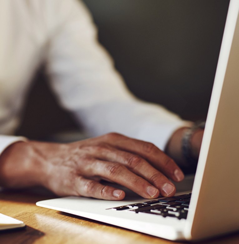 A man types on a laptop's keypad
