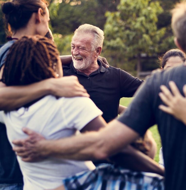 A group of volunteers hug together at an event