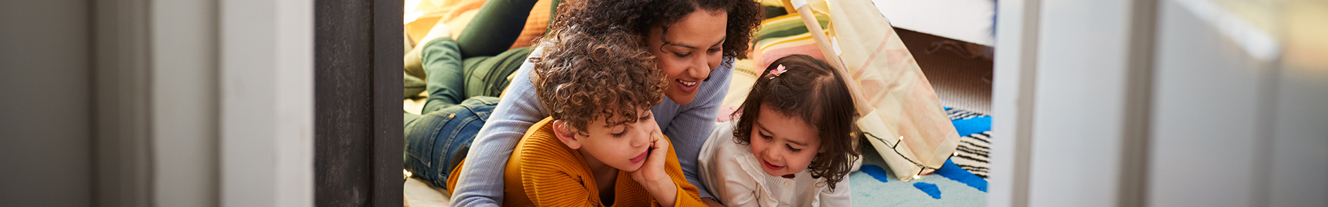 Mother and her children reading together in a den