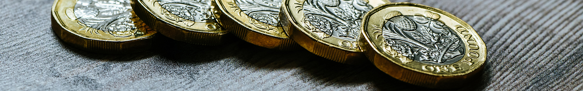 Pound coins on a wooden table