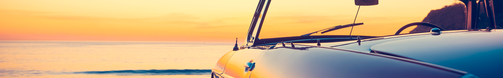 Retirement sports car sitting on beach at sunset