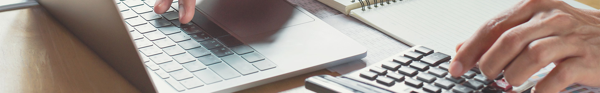 Calculating tax savings on calculator and laptop