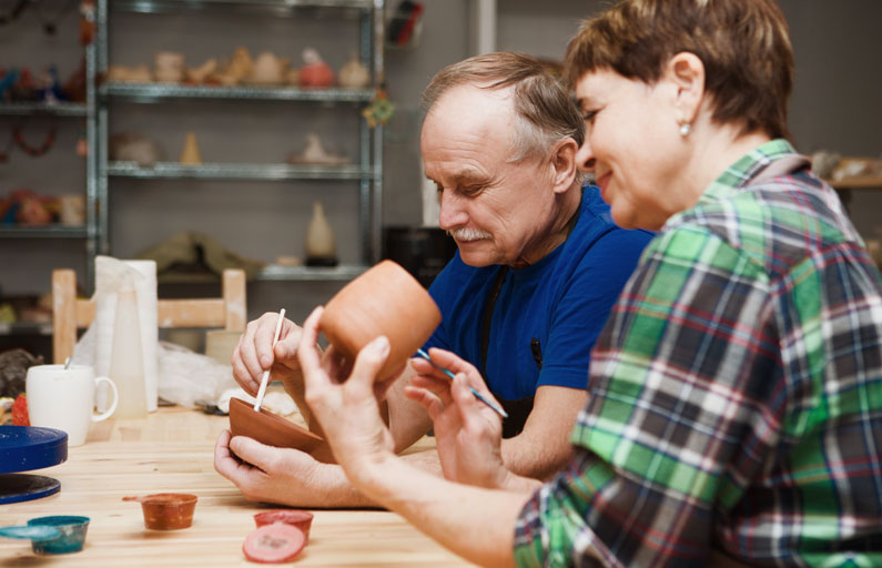 Middle-aged couple paint pottery together