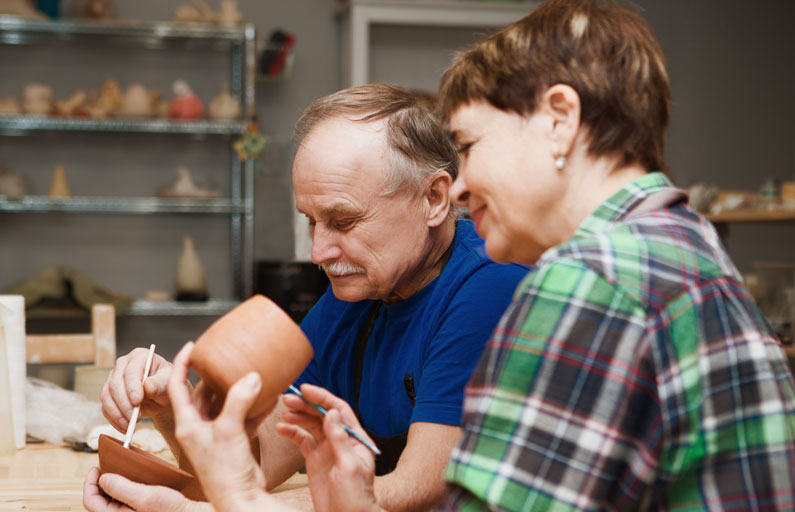 Middle-aged couple paint pottery together