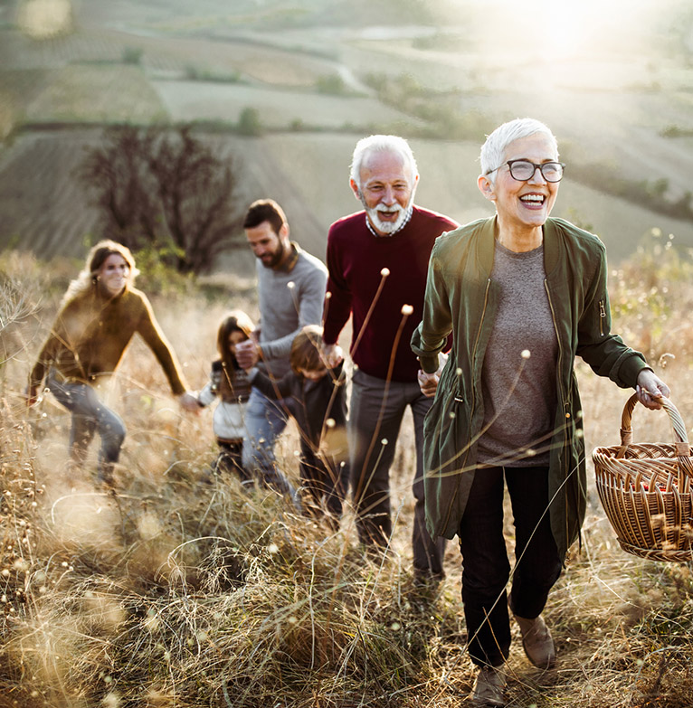 A family walk up a hill for a picnic