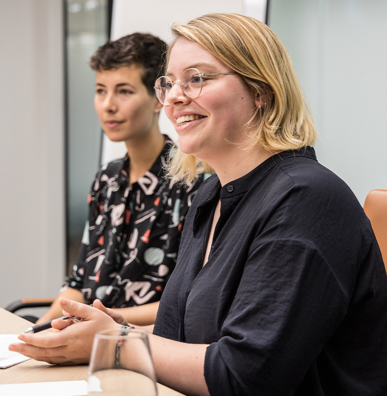 Members of staff speaking to one another in a meeting room